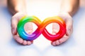 Colorful autism infinity rainbow symbol sign in outstretched woman hands. World autism awareness day, autism rights