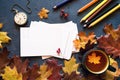 Colorful autumn background with a cup of tea and clean white cards for your text, with bright autumn leaves, pocket watch and colo Royalty Free Stock Photo