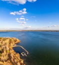 Colorful autumn forest with trees on the shore of a blue lake - top aerial view Royalty Free Stock Photo