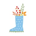 Colorful autumn leaves in a blue rubber boot