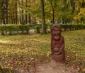 Colorful autumn park with a carved from a tree figure
