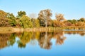 Colorful autumn trees reflecting in calm water surface. Beautiful autumn landscape Royalty Free Stock Photo