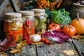 Colorful autumn vegetables in jars are placed on a wooden table in a rustic style Royalty Free Stock Photo