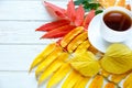 Colorful Autumn yellow, orange and red leaves and cup of coffee or hot tea on the white wooden background. change season, autumn