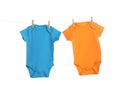 Colorful baby onesies hanging on clothes line. Laundry day Royalty Free Stock Photo