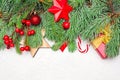 Colorful background with Christmas tree branch, red holly berries, gift, candy and baubles. Christmas composition, top view flat Royalty Free Stock Photo