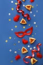 Carnival mask and Hamantaschen cookies for Purim holiday on color background Royalty Free Stock Photo