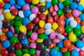 Colorful background of multicolored candy dragees. Round  scattered sweets on a yellow bright background. Happy multicolor texture Royalty Free Stock Photo