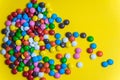 Colorful background of multicolored candy dragees. Round  scattered sweets on a yellow bright background. Happy multicolor texture Royalty Free Stock Photo