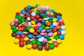 Colorful background of multicolored candy dragees. Round  scattered sweets on a yellow bright background. Happy multicolor texture Royalty Free Stock Photo