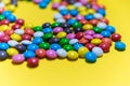 Colorful background of multicolored candy dragees. Round  scattered sweets on a yellow bright background. Happy multicolor texture Royalty Free Stock Photo