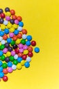 Colorful background of multicolored candy dragees. Round  scattered sweets on a yellow bright background. Happy multicolor texture Royalty Free Stock Photo