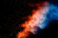 Colorful background of pastel powder explosion.Rainbow color dust splash on black background