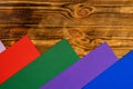 Colorful background with rainbow colored stripes and brown wooden texture. Red, green, purple and blue stripes of paper Royalty Free Stock Photo