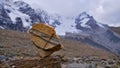 Colorful balanced rock with marbling pattern and visible rock strata with glacier \