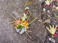 Colorful Balinese canang sari offering with flowers on the stre