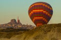 Colorful balloon on the background of morning sky, beautiful rocky valleys and Uchisar castle. Cappadocia, Turkey