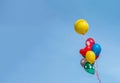 Colorful balloon floating in mid air against a bright blue sky. Royalty Free Stock Photo