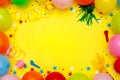 Colorful balloons and confetti on yellow table top view. Festive or party background. Flat lay style. Birthday greeting card. Royalty Free Stock Photo