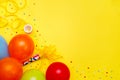 Colorful balloons and confetti on yellow table top view. Festive or party background. Flat lay style. Birthday greeting card. Royalty Free Stock Photo