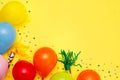 Colorful balloons and confetti on yellow table top view. Festive or party background. Flat lay style. Birthday greeting card. Royalty Free Stock Photo