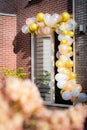 Colorful balloons decorate the doorway of a groom`s childhood home