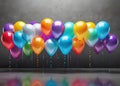 Colorful balloons hanging on grey wall. Party and celebration concept.