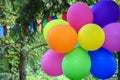 Colorful balloons and multicolored triangular flags on background of autumn foliage in city Park. Close-up.