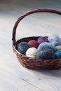 Colorful balls of wool yarn in a basket on the rustic background Royalty Free Stock Photo