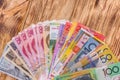 Colorful banknotes in fan on wooden table Royalty Free Stock Photo