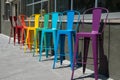 Colorful barstools lined up outside