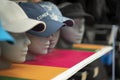 Colorful Baseball Caps with different model peaks hanging on wall. Selective Focus. Royalty Free Stock Photo