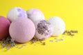 Colorful bath bombs, salt and dried lavender on yellow background, closeup Royalty Free Stock Photo