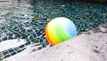 Colorful beach ball floating in a blue swimming pool Royalty Free Stock Photo