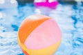 Colorful Beach ball floating in swimming pool. Abstract concept of summer vacations, relaxation and have fun in the Royalty Free Stock Photo