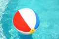 Colorful beach ball floating in swimming pool on sunny day Royalty Free Stock Photo