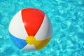 Colorful beach ball floating in swimming pool on sunny day Royalty Free Stock Photo