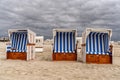 Colorful beach baskets on an idyllic golden sand beach on the German Wadden Sea coast under an expressive sky