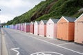 Colorful Beach huts, in orange, peach and pink colors, at the boulevard in Bournemouth, Dorset, UK, England on a cloudy day in