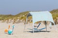 Colorful beach tent and chairs in front of the sand dunes