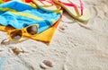 Colorful beach towel, sunglasses and thongs