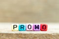 Colorful bead with letter in word promo on wood background