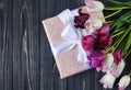 Colorful beautiful pink violet tulips and gift box on gray wooden table. Valentines, spring background. Royalty Free Stock Photo