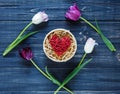 Colorful beautiful pink violet tulips and red heart in round wooden box on gray wooden table. Valentines, spring background. Royalty Free Stock Photo