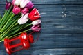 Colorful beautiful pink violet tulips and red lantern on gray wooden background. Valentines, spring background. floral mock up. Royalty Free Stock Photo