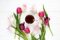 Colorful beautiful tulips and coffee cup on the white wooden table. Valentines, spring background. floral mock up Royalty Free Stock Photo