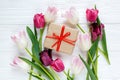 Colorful beautiful tulips and gift box on the white wooden table. Valentines, spring background. floral mock up with copyspace Royalty Free Stock Photo