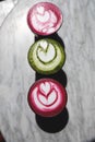 Colorful Beetroot, matcha lattes are on the marble table.
