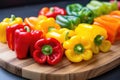 colorful bell peppers cut in half on a wooden chopping board Royalty Free Stock Photo