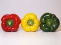 Green, Yellow and Red Fresh Bell Peppers on a White Surface Royalty Free Stock Photo